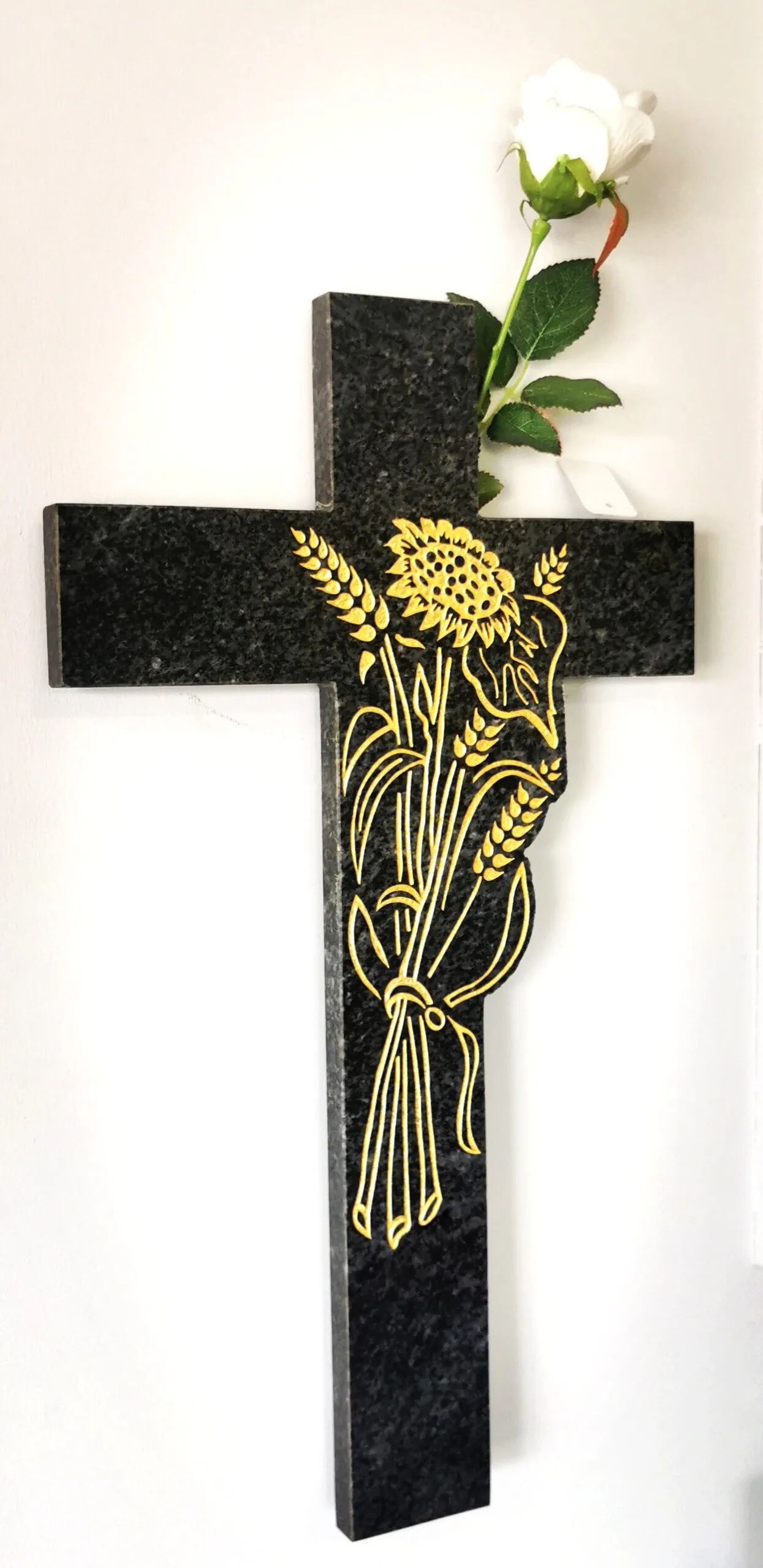 Croix funéraire en granit noir gravée d'un bouquet de tournesols et épis de blé dorés