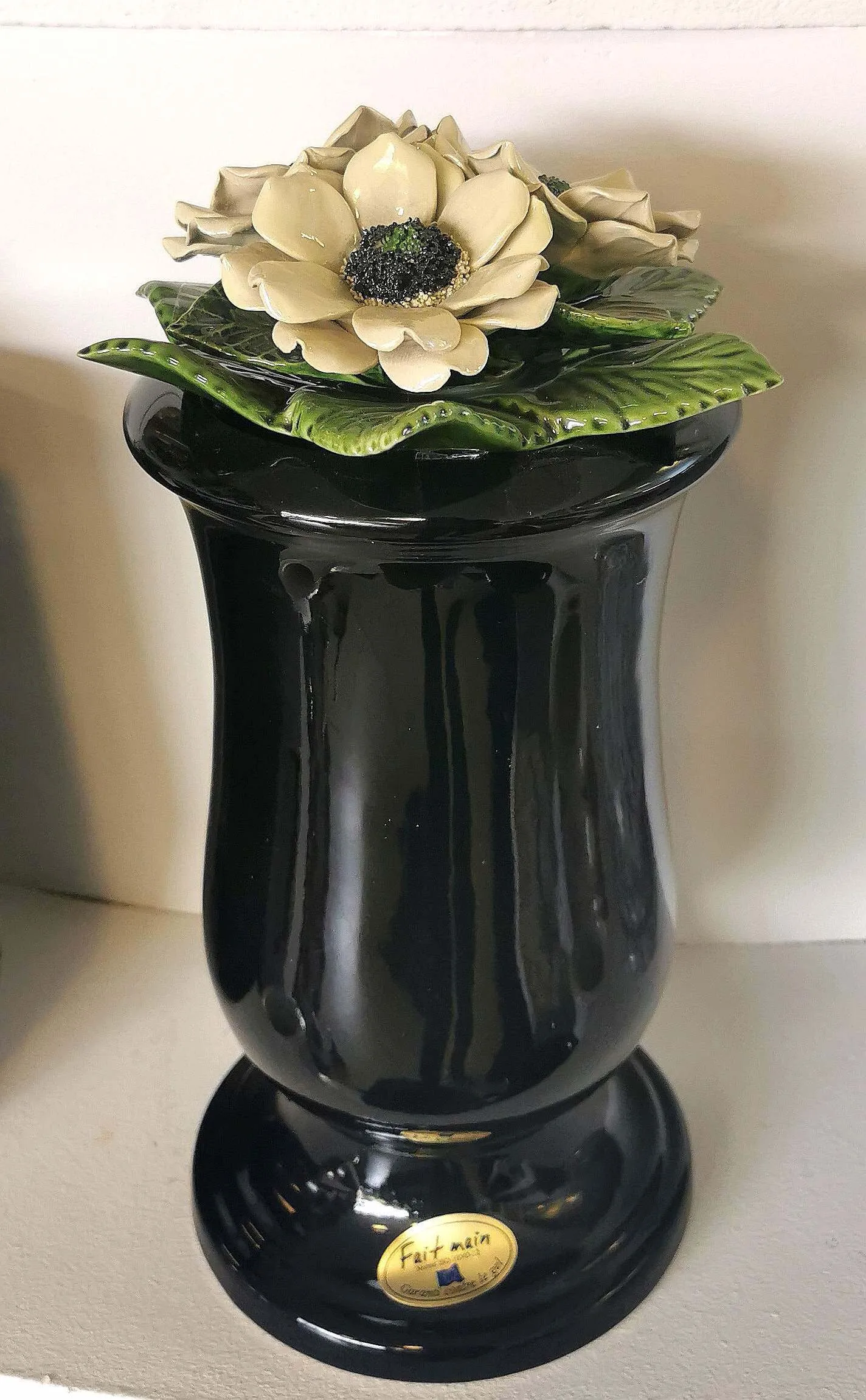 Urne cinéraire en céramique noire décorée de fleurs sculptées blanches
