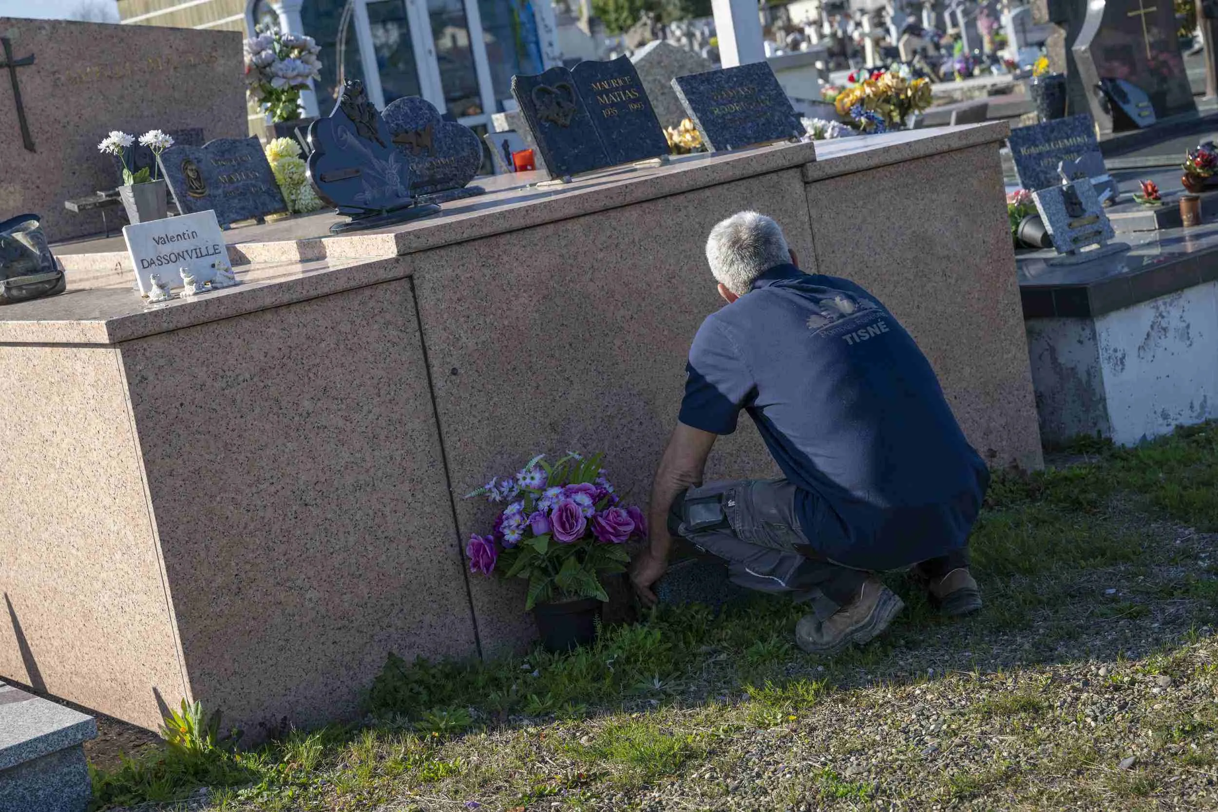 Marbrier funéraire effectuant des travaux d'entretien sur un monument dans un cimetière