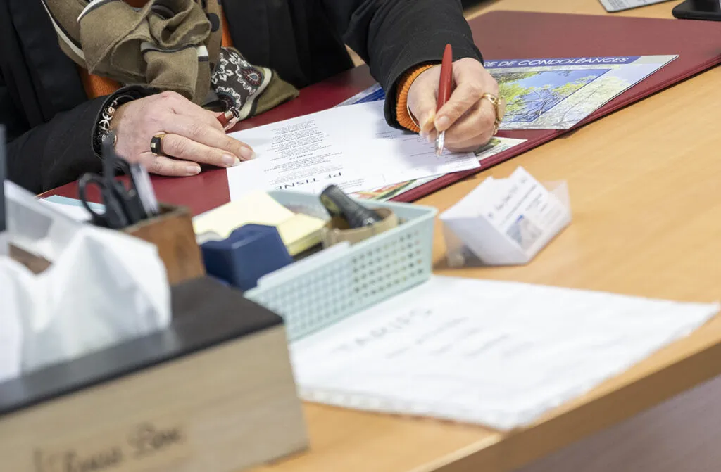 Gros plan sur la signature d'un contrat d'obsèques aux Pompes Funèbres Tisné