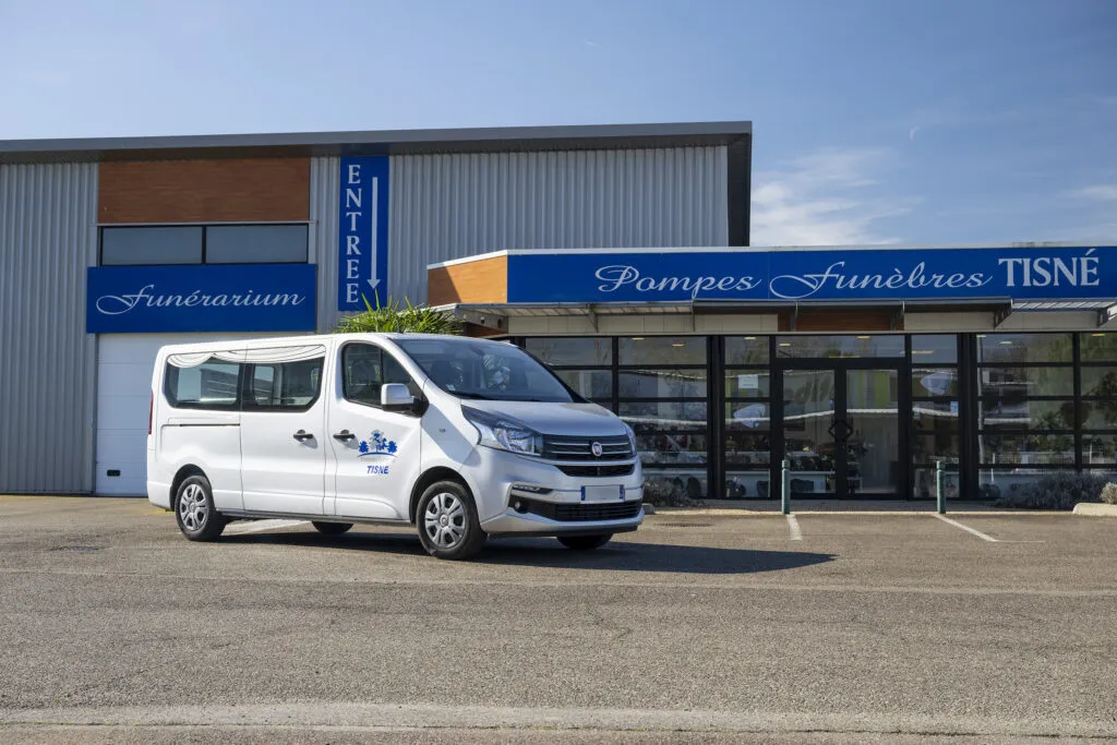 Fourgon funéraire garé devant le funérarium et l'agence des Pompes Funèbres Tisné